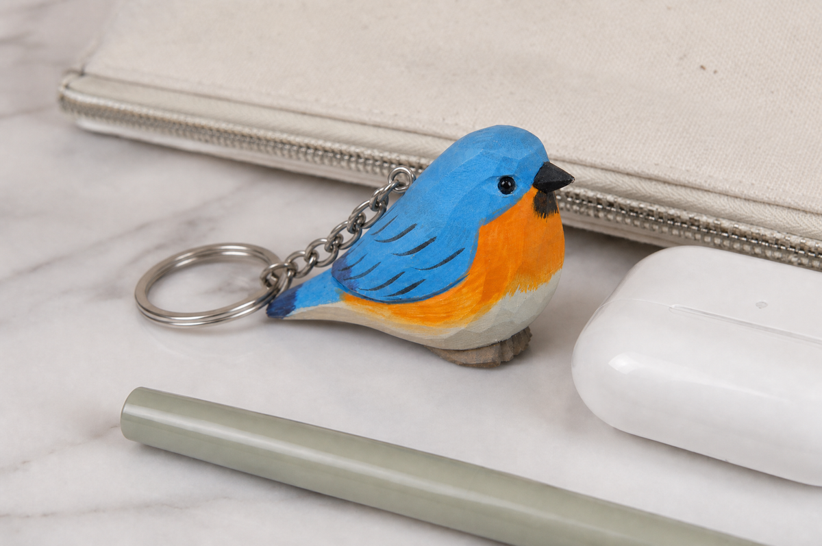 Eastern Bluebird hand-carved wooden keychain by Selsela, in a styled scene