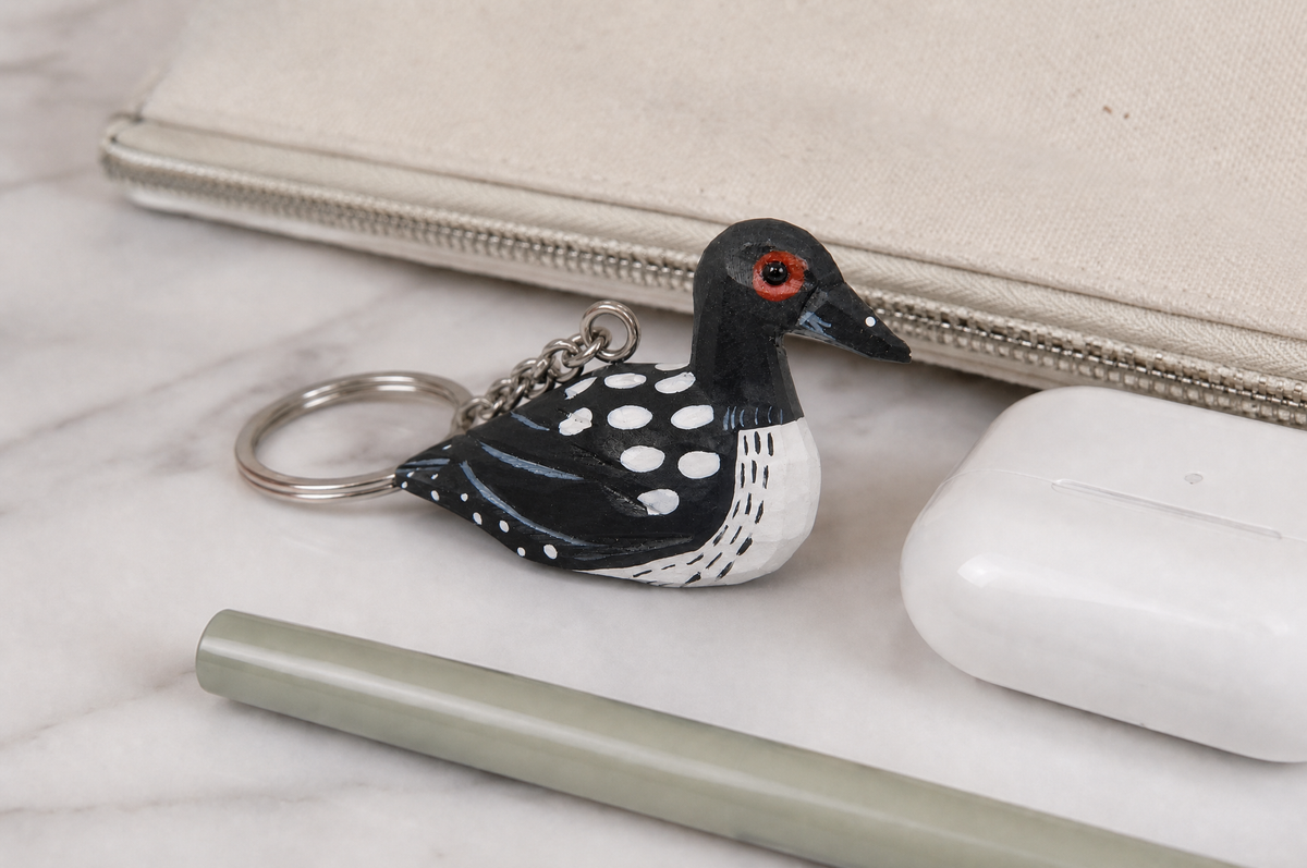 Common Loon hand-carved wooden keychain by Selsela, in a styled scene