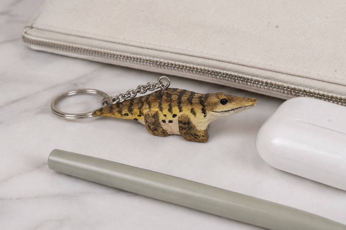 Crocodile hand-carved wooden keychain by Selsela, in a styled scene