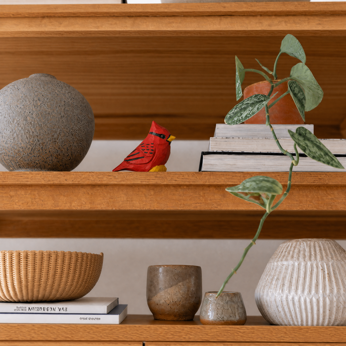 Cardinal Male hand-carved wooden figurine by Selsela, styled in a home setting