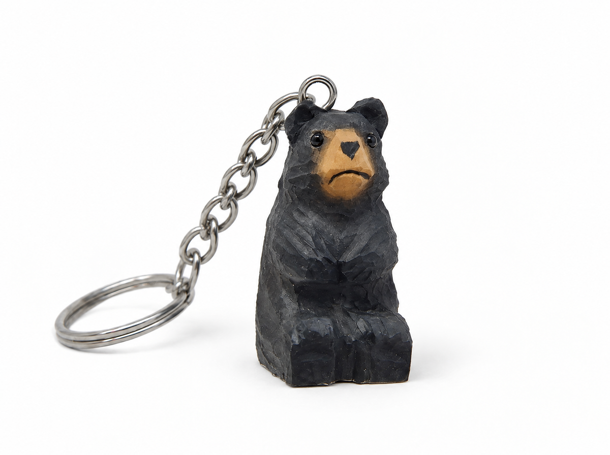 Black Bear hand-carved wooden keychain by Selsela, on a plain background