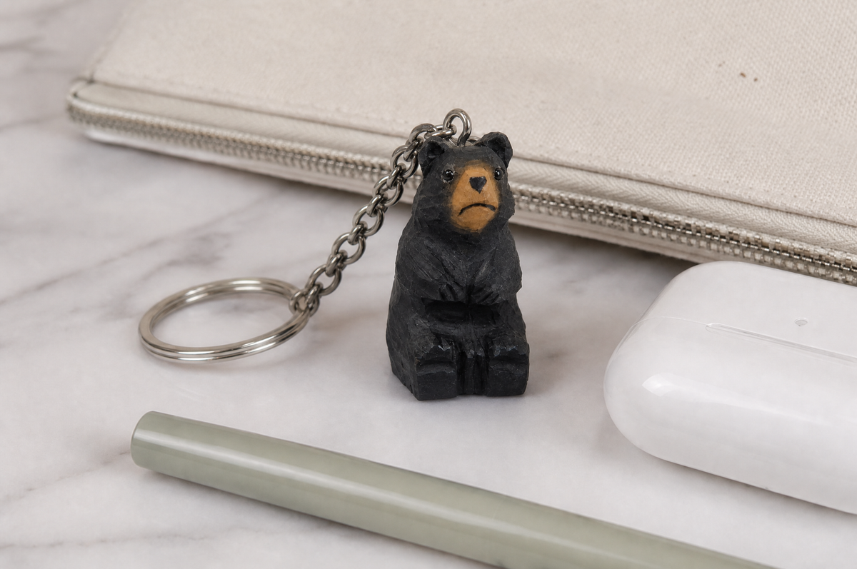 Black Bear hand-carved wooden keychain by Selsela, in a styled scene