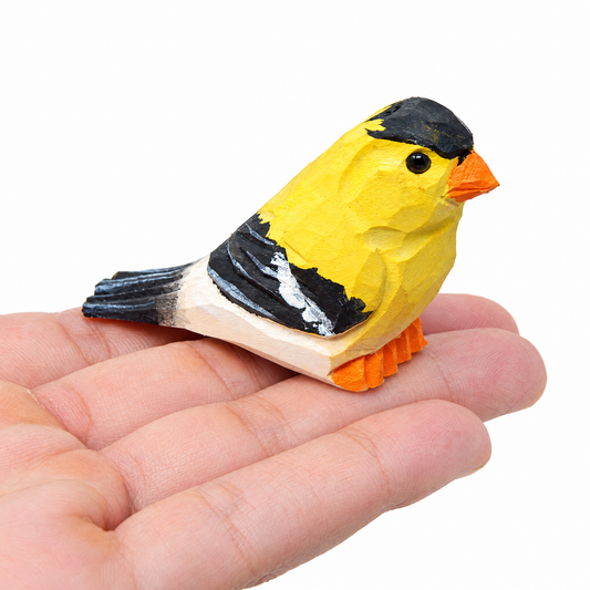 American Goldfinch hand-carved wooden figurine by Selsela, on a plain background
