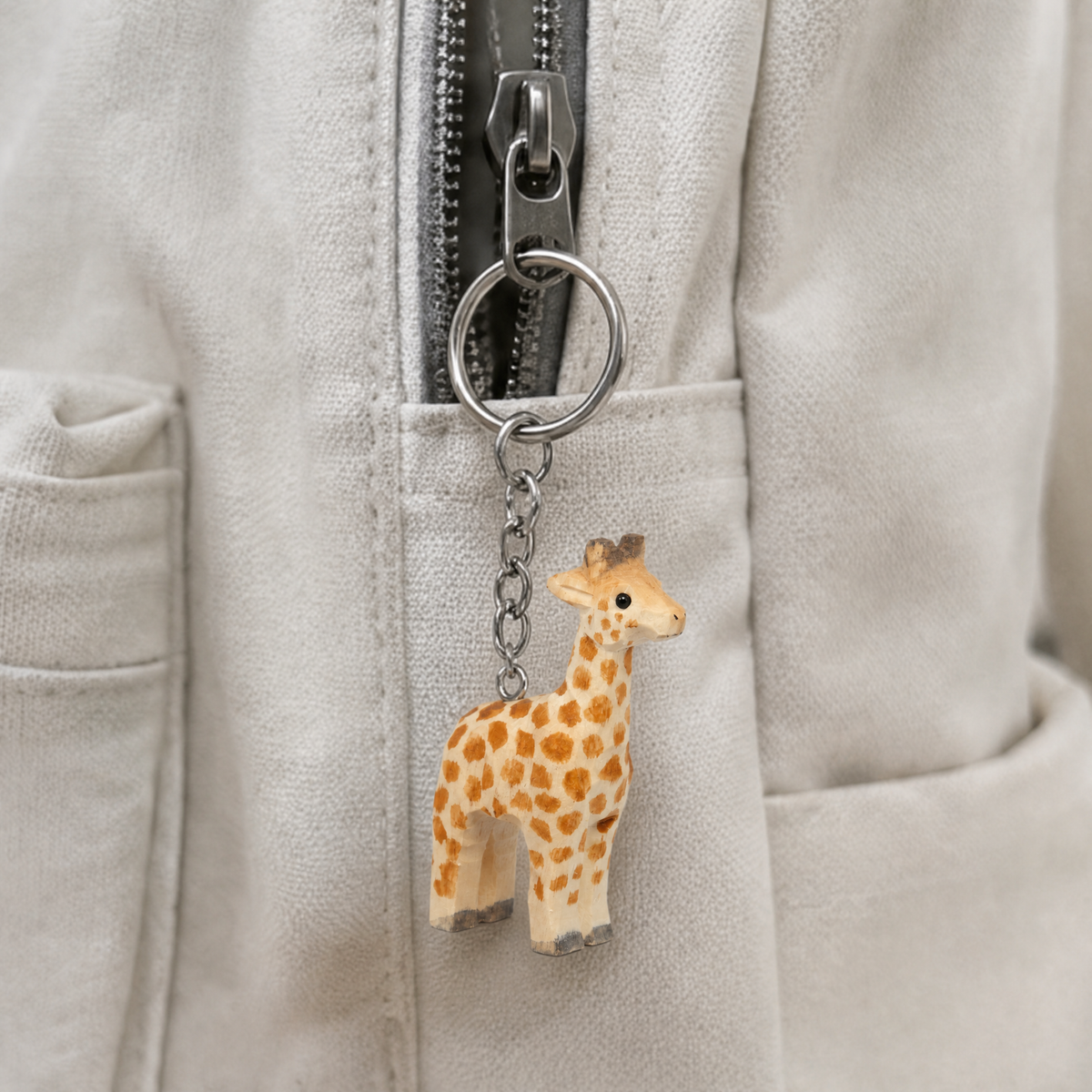 Giraffe hand-carved wooden keychain by Selsela, in a styled scene