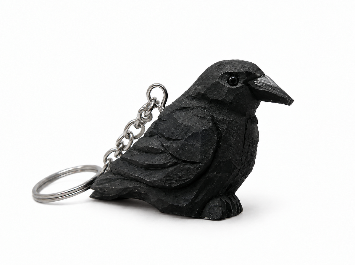 Raven hand-carved wooden keychain by Selsela, on a plain background