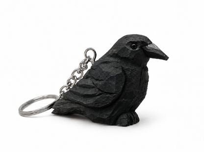 Raven hand-carved wooden keychain by Selsela, on a plain background