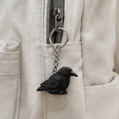 Raven hand-carved wooden keychain by Selsela, in a styled scene