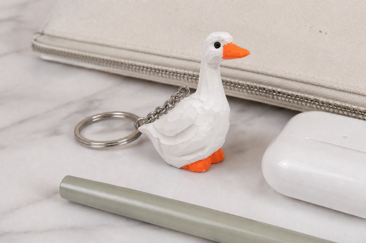 White Goose hand-carved wooden keychain by Selsela, in a styled scene