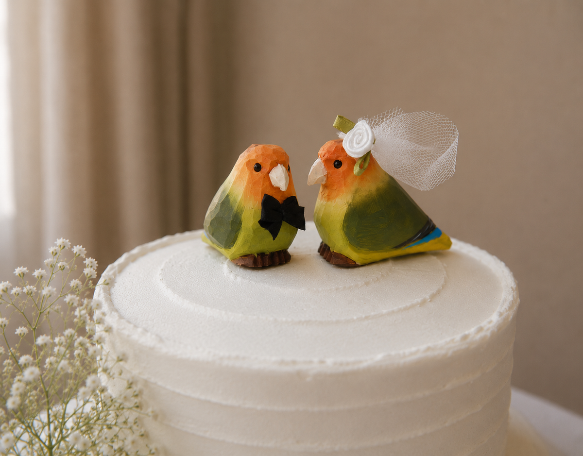 Lovebirds hand-carved wooden cake topper by Selsela, bride and groom pair on a wedding cake