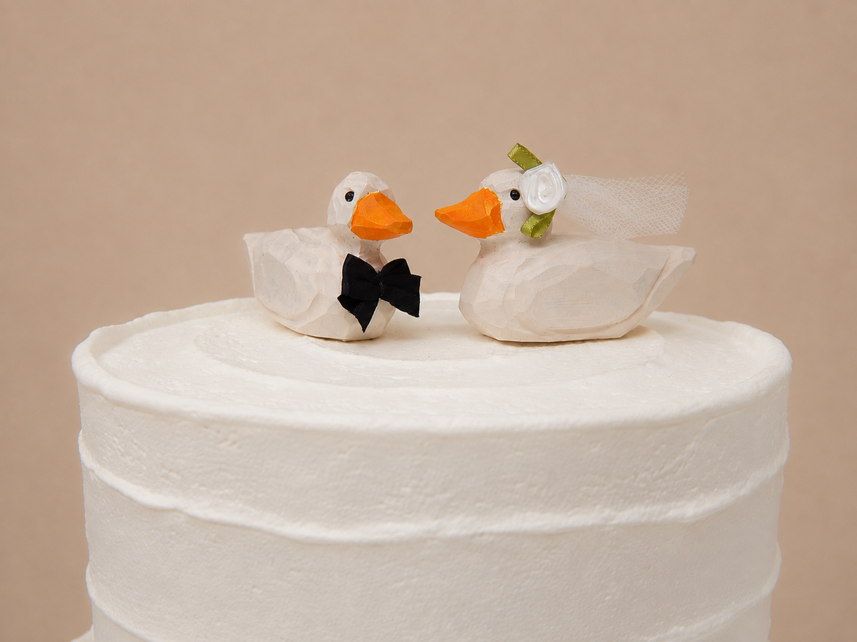 Pekin Duck hand-carved wooden cake topper by Selsela, bride and groom pair on a wedding cake
