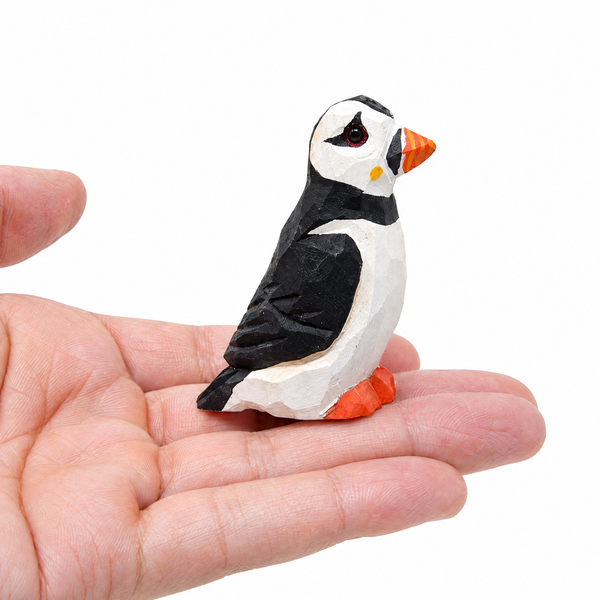 Puffin hand-carved wooden figurine by Selsela, on a plain background