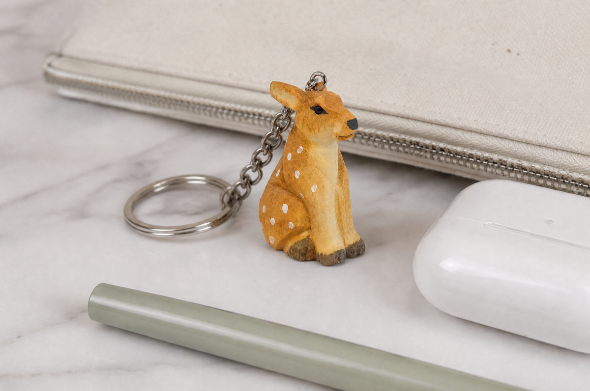 Deer hand-carved wooden keychain by Selsela, in a styled scene