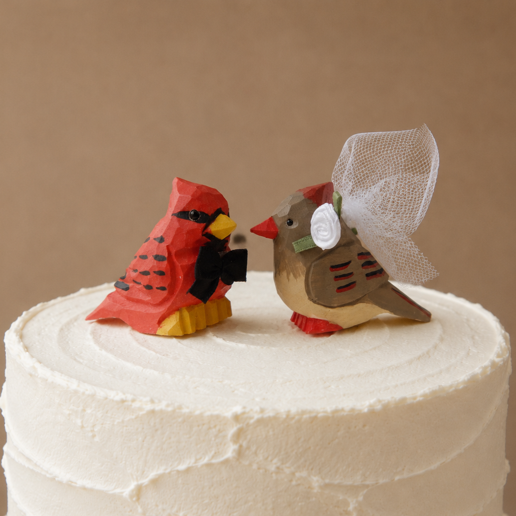Cardinal Male hand-carved wooden cake topper by Selsela, bride and groom pair on a wedding cake