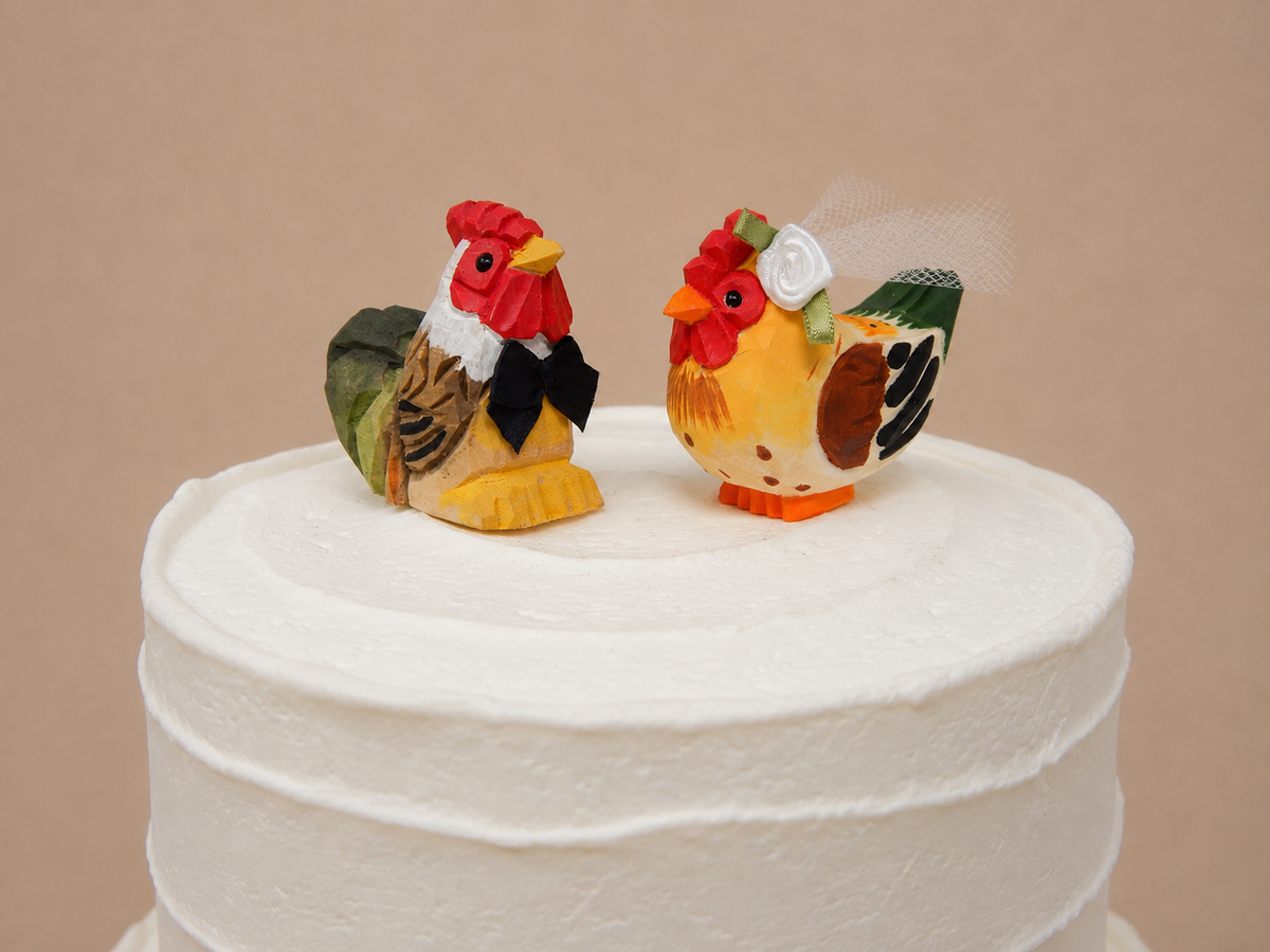 Rooster hand-carved wooden cake topper by Selsela, bride and groom pair on a wedding cake