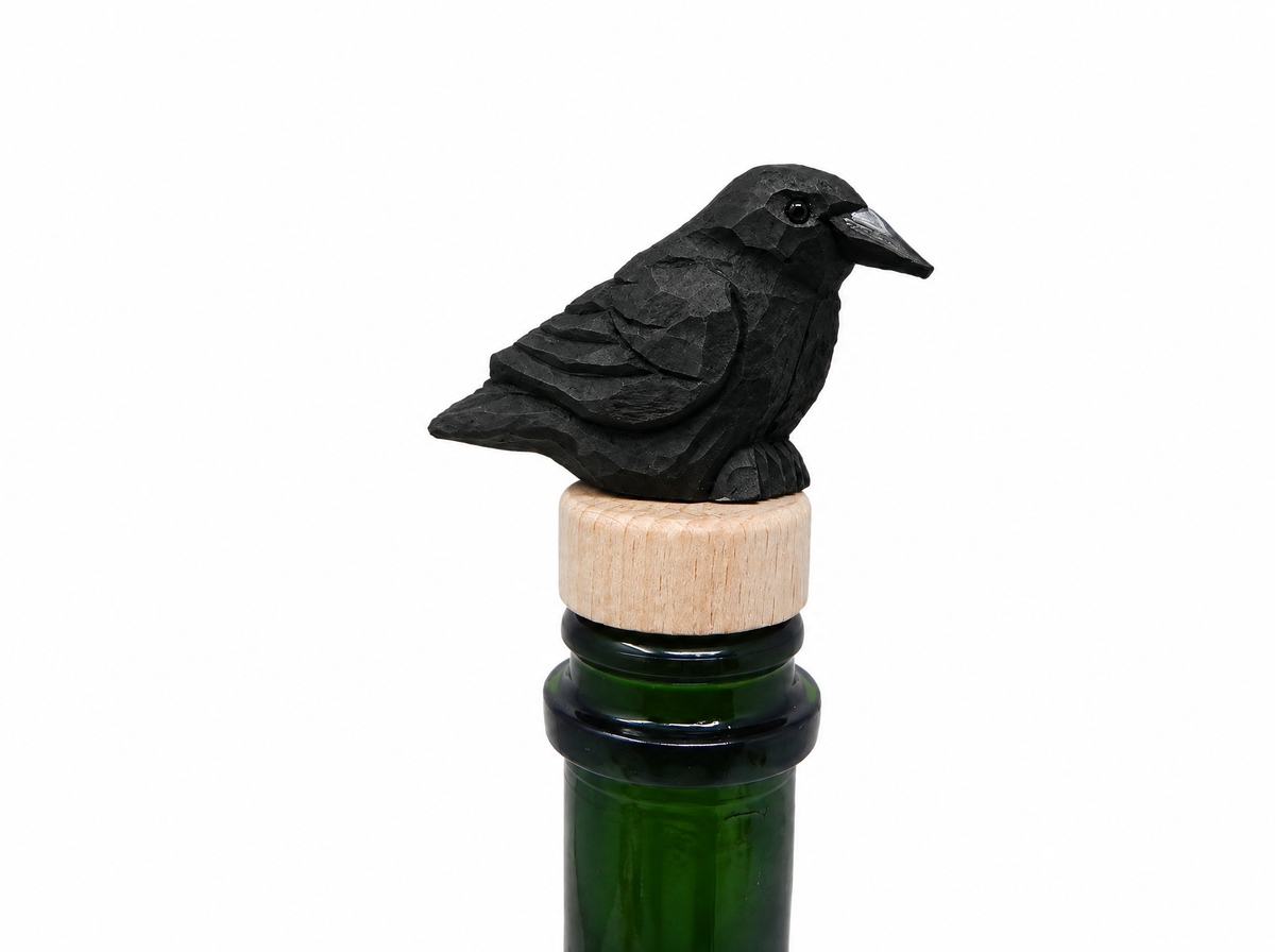 Raven hand-carved wooden wine stopper by Selsela, on a plain background