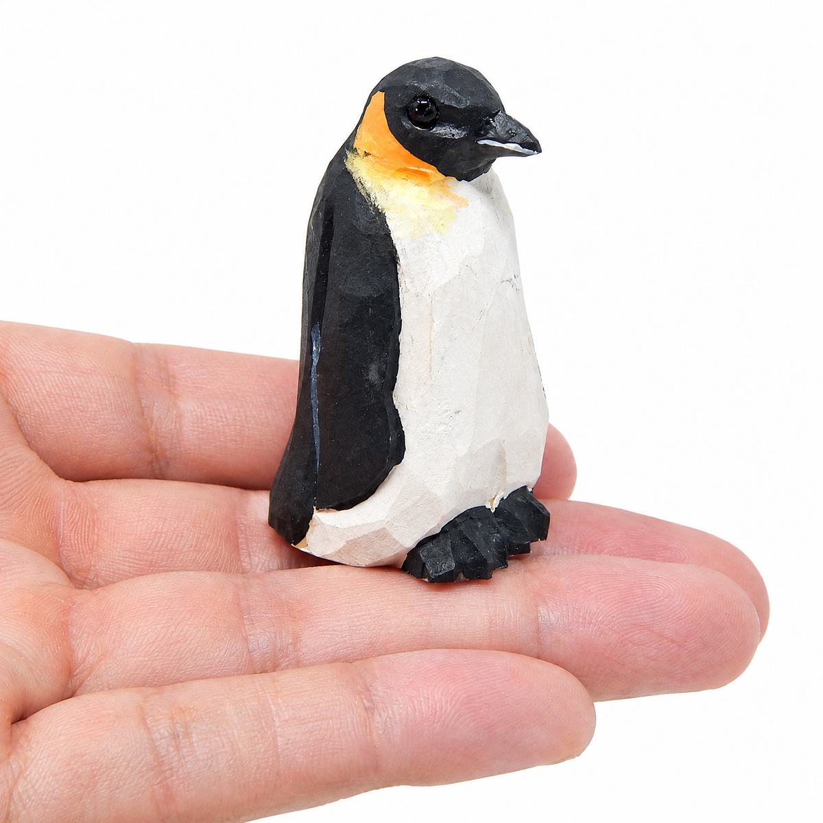 Penguin hand-carved wooden figurine by Selsela, on a plain background