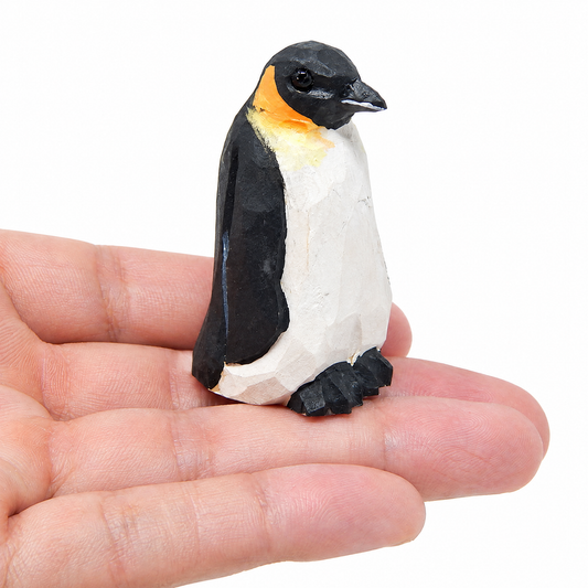 Penguin hand-carved wooden figurine by Selsela, on a plain background