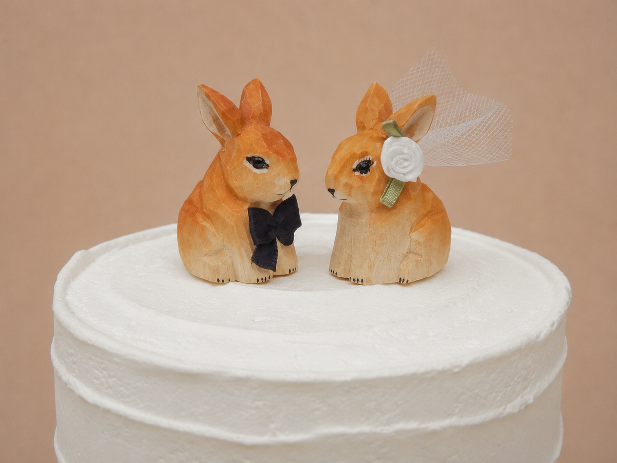 Brown Rabbit hand-carved wooden cake topper by Selsela, bride and groom pair on a wedding cake