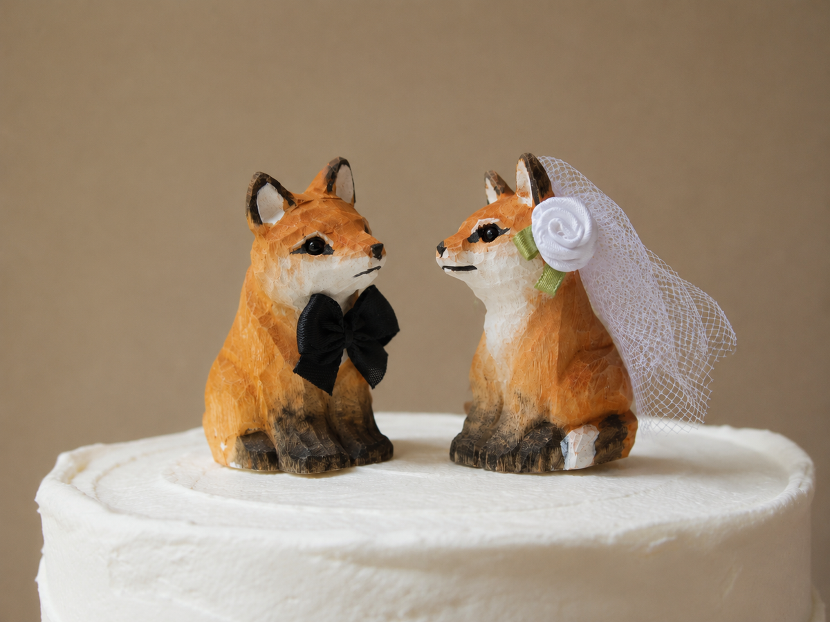 Red Fox hand-carved wooden cake topper by Selsela, bride and groom pair on a wedding cake
