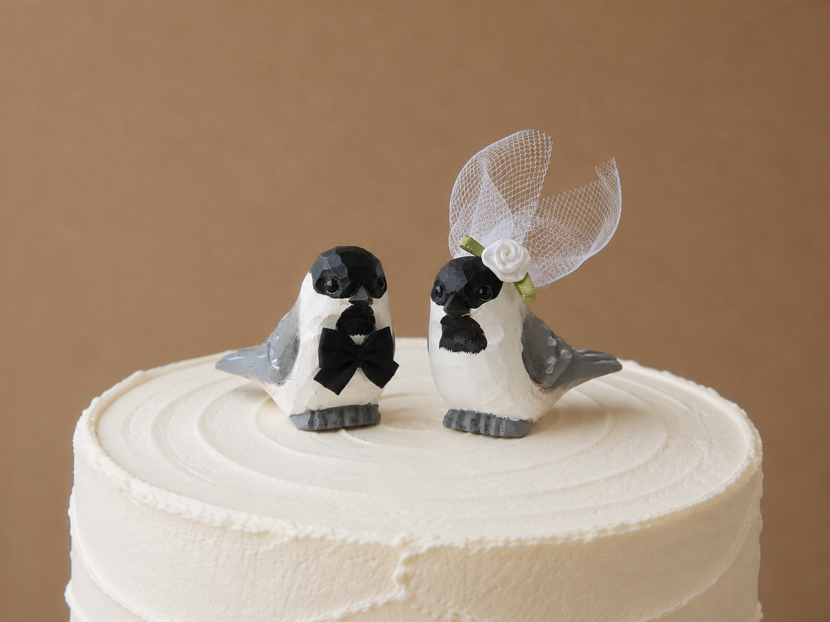 Chickadee hand-carved wooden cake topper by Selsela, bride and groom pair on a wedding cake