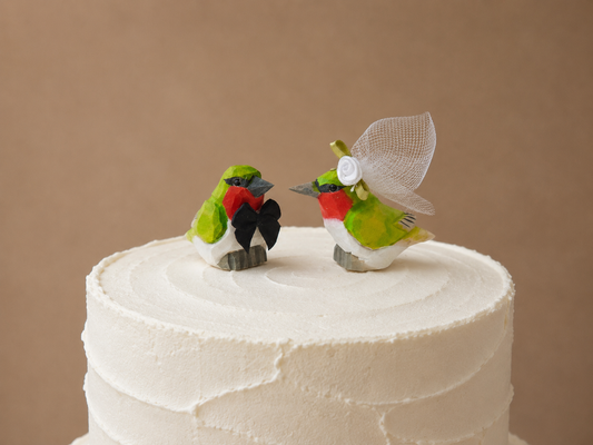 Hummingbird hand-carved wooden cake topper by Selsela, bride and groom pair on a wedding cake