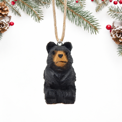 Black Bear hand-carved wooden ornament by Selsela, on a plain background