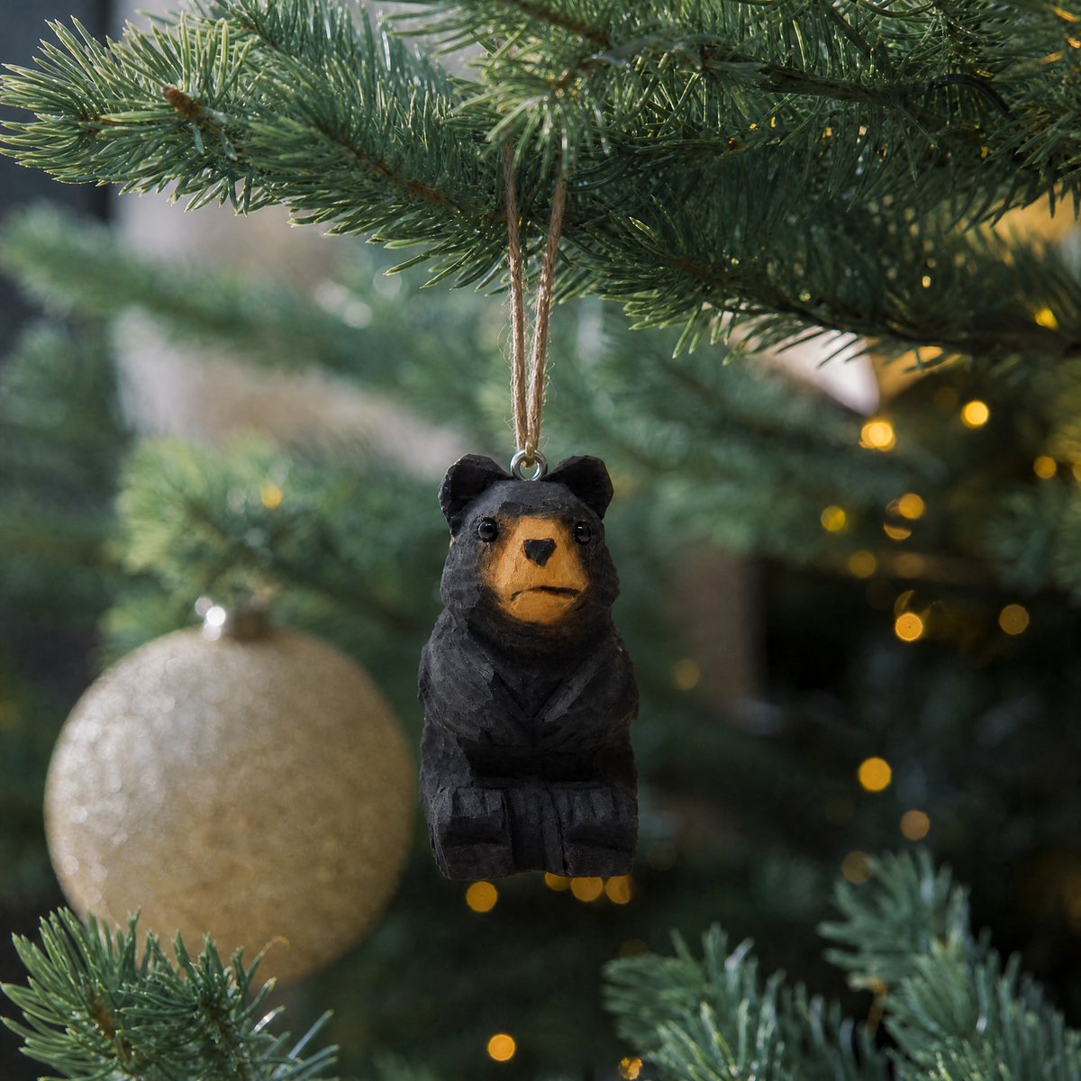 Black Bear hand-carved wooden ornament by Selsela, hanging on a Christmas tree