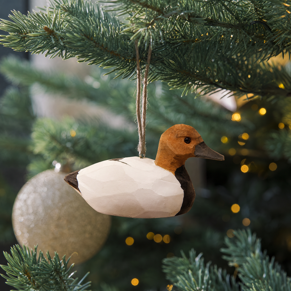 Canvasback Duck hand-carved wooden ornament by Selsela, hanging on a Christmas tree