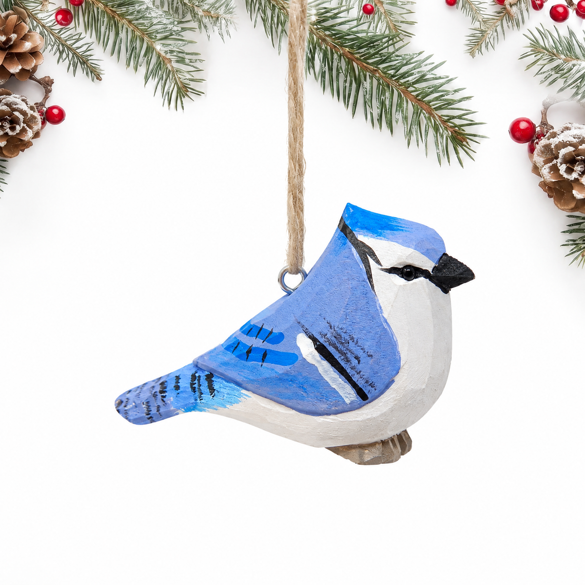 Blue Jay hand-carved wooden ornament by Selsela, on a plain background