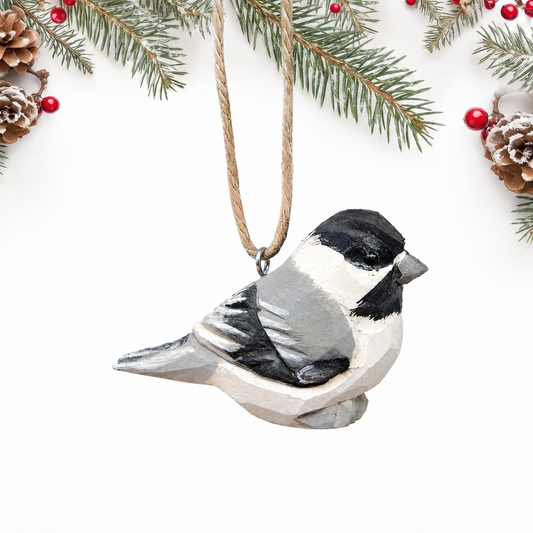 Chickadee hand-carved wooden ornament by Selsela, on a plain background