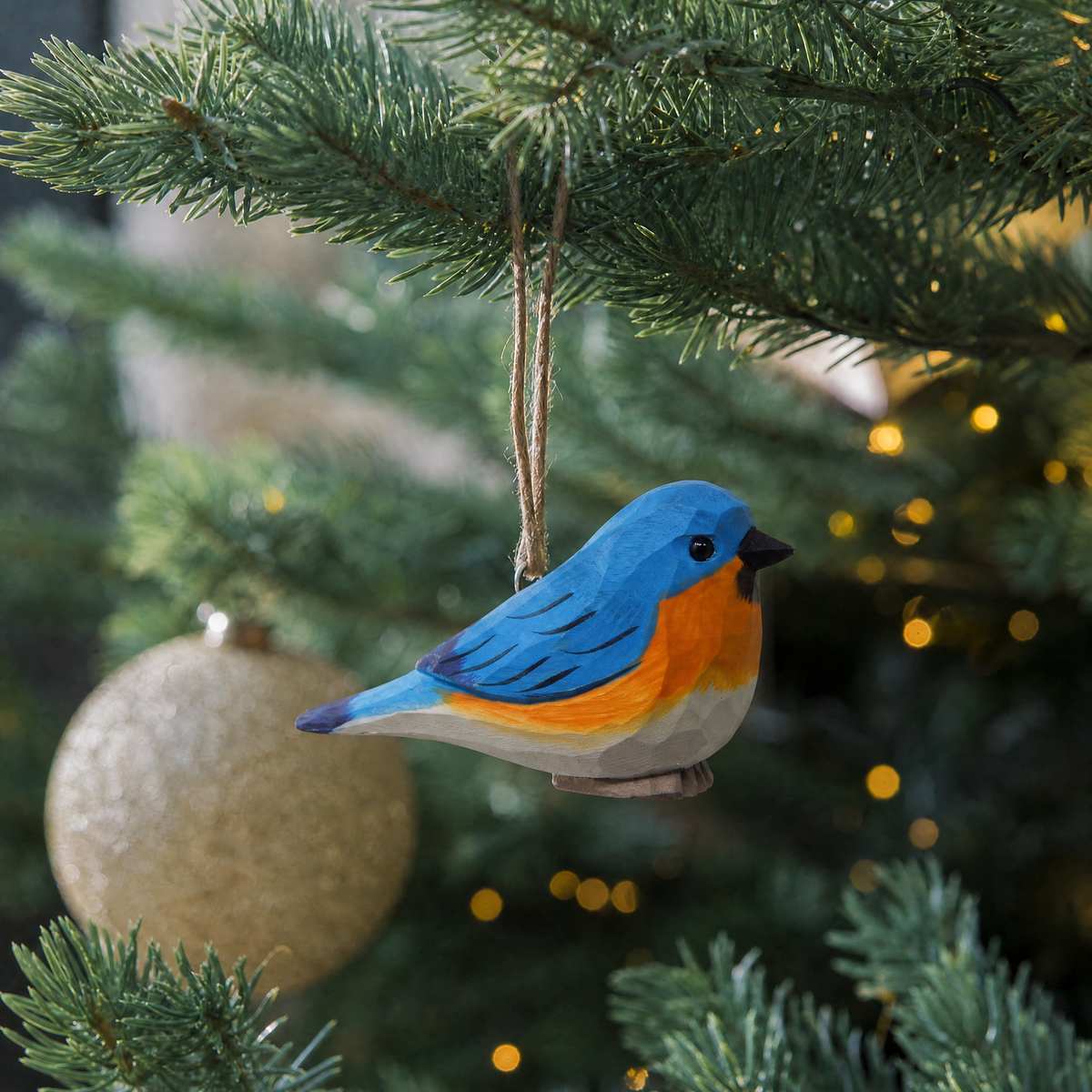 Eastern Bluebird hand-carved wooden ornament by Selsela, hanging on a Christmas tree