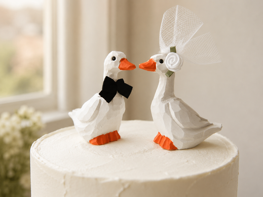 White Goose hand-carved wooden cake topper by Selsela, bride and groom pair on a wedding cake