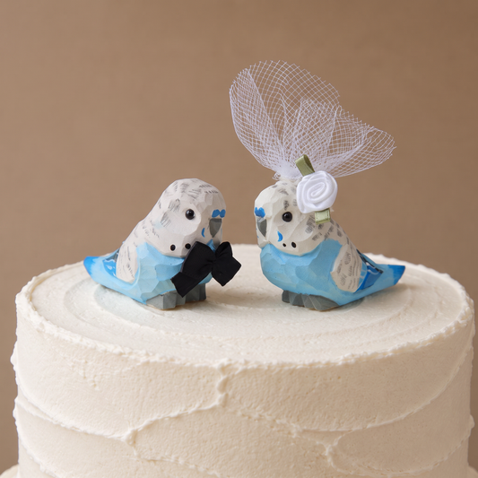 Blue Parakeet hand-carved wooden cake topper by Selsela, bride and groom pair on a wedding cake