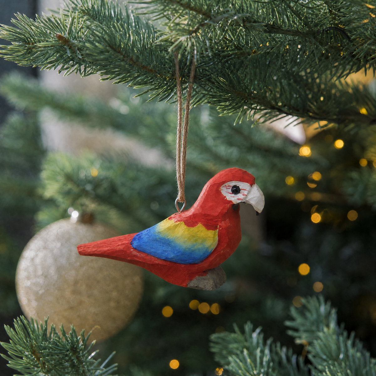 Macaw hand-carved wooden ornament by Selsela, hanging on a Christmas tree