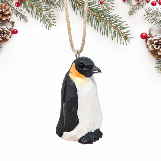Penguin hand-carved wooden ornament by Selsela, on a plain background