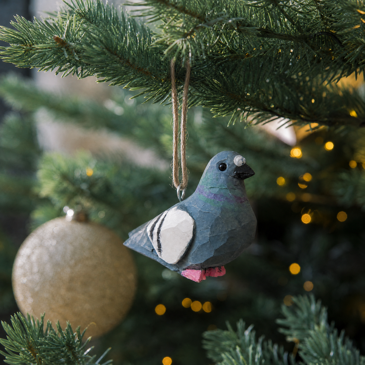 Pigeon hand-carved wooden ornament by Selsela, hanging on a Christmas tree