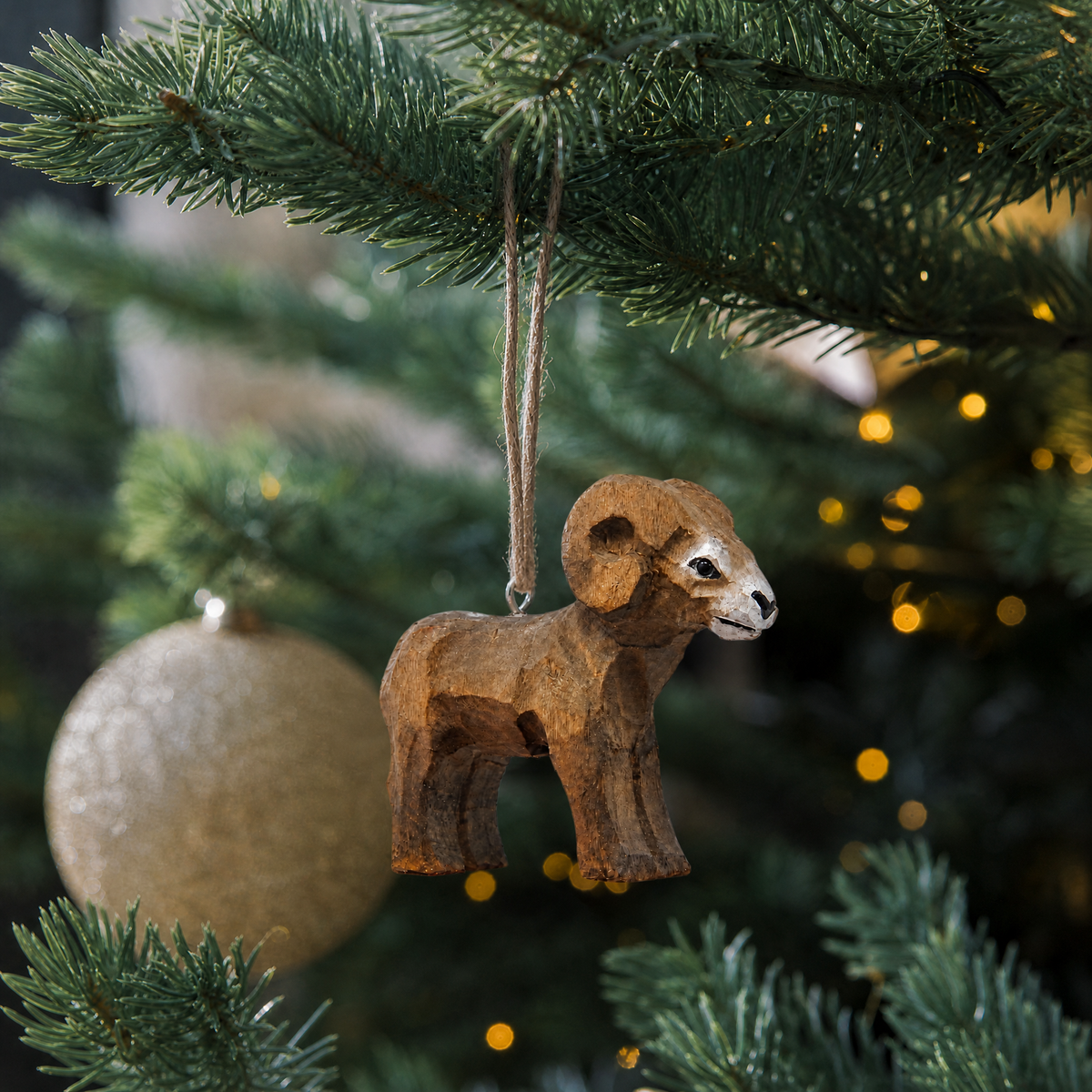 Ram hand-carved wooden ornament by Selsela, hanging on a Christmas tree