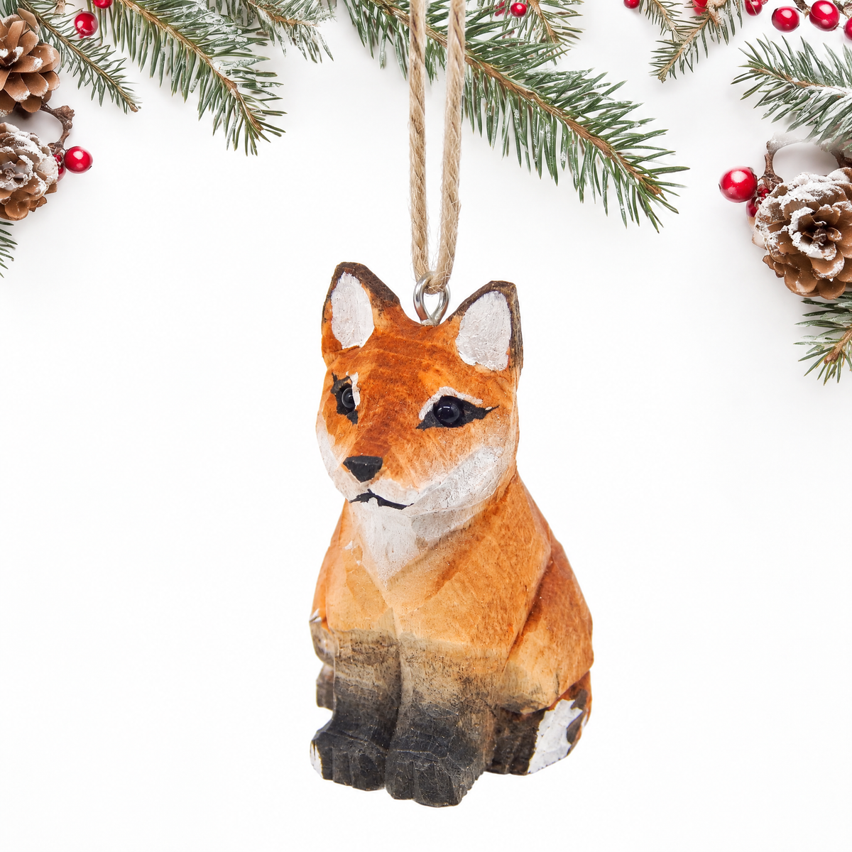 Red Fox hand-carved wooden ornament by Selsela, on a plain background