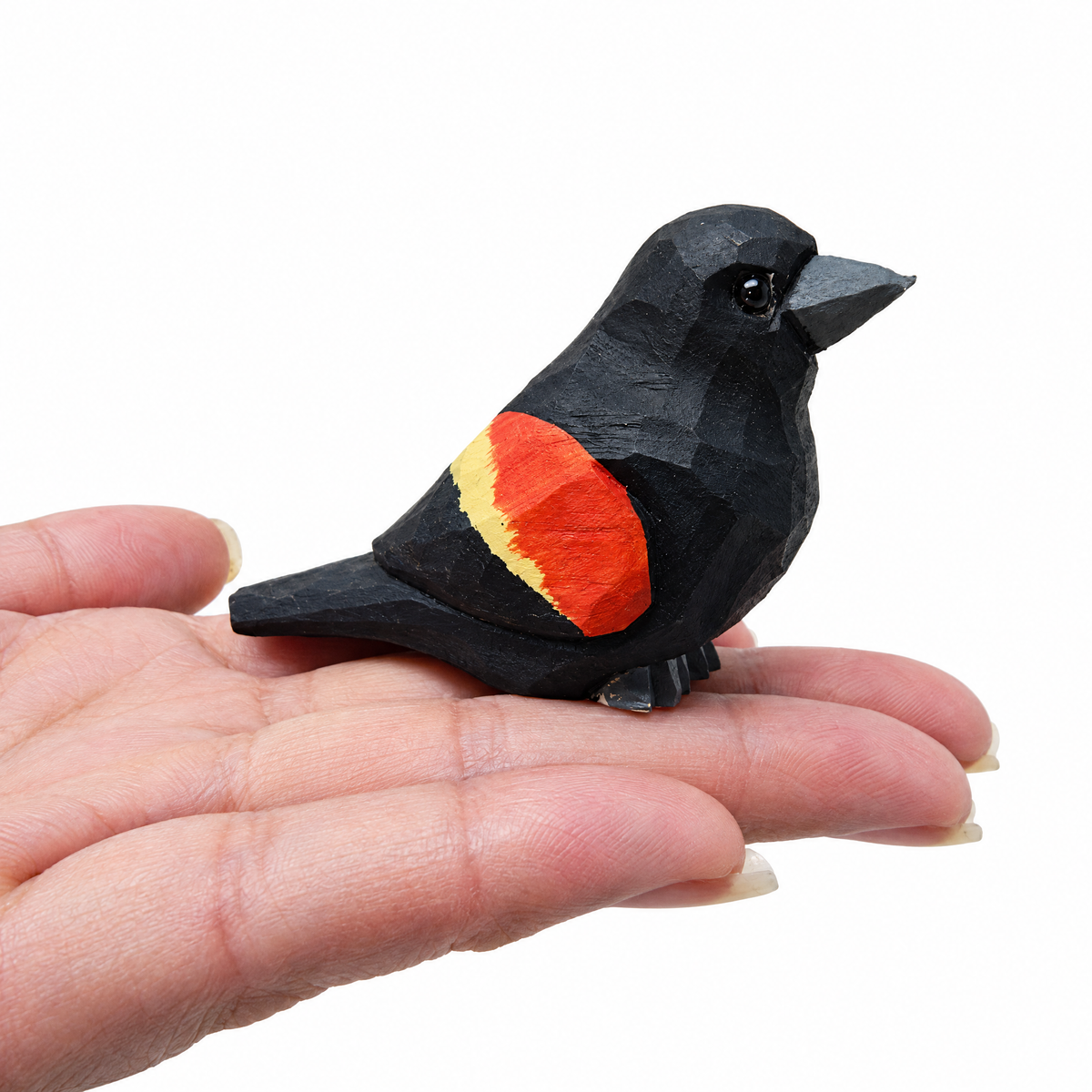 Red-Winged Blackbird hand-carved wooden figurine by Selsela, on a plain background