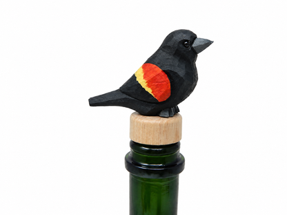 Red-Winged Blackbird hand-carved wooden wine stopper by Selsela, on a plain background