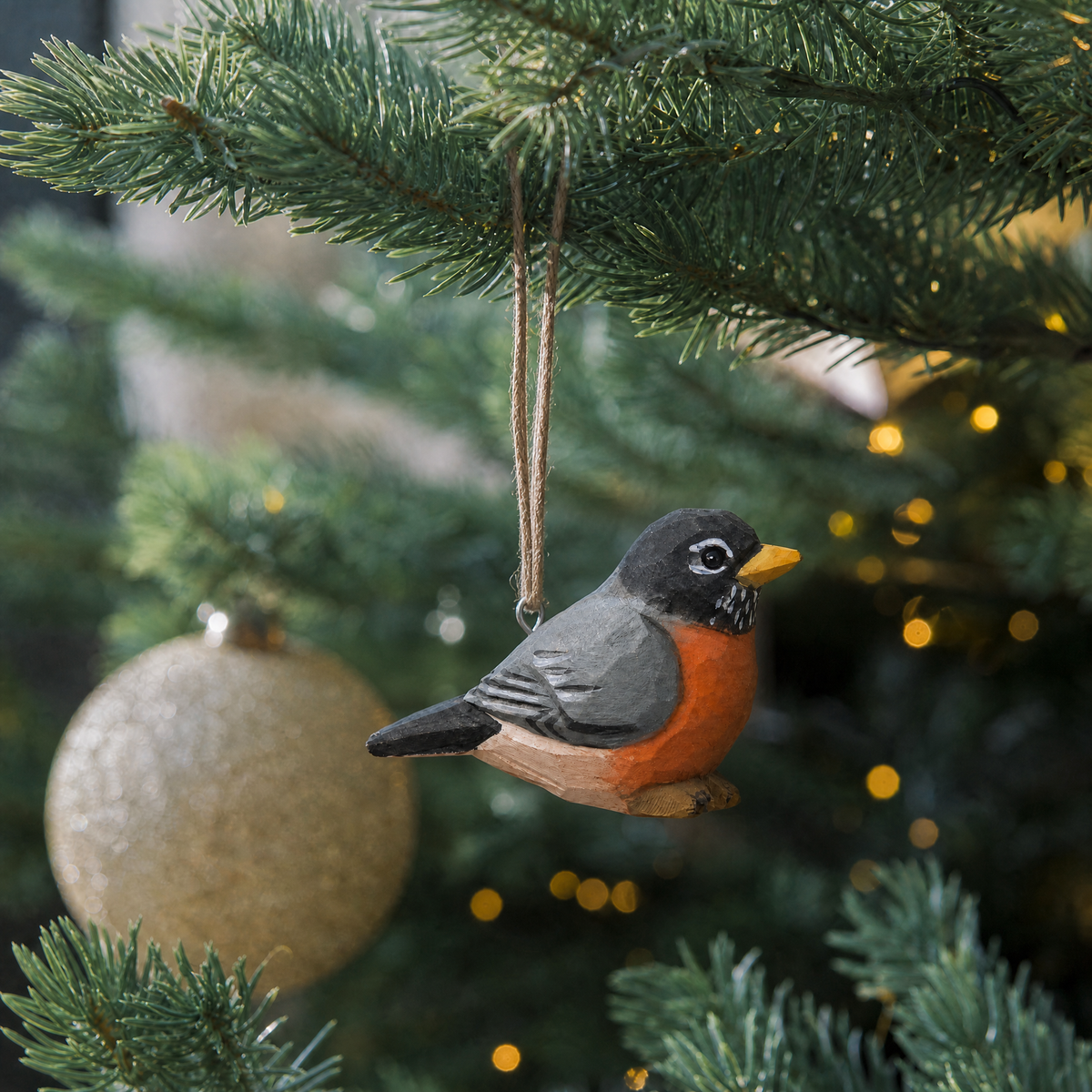 American Robin hand-carved wooden ornament by Selsela, hanging on a Christmas tree