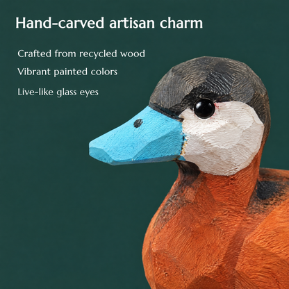 Close-up of the carved Ruddy Duck head with its black cap, white cheek, glass eye and sky blue bill. Text reads: Hand-carved artisan charm, crafted from recycled wood, vibrant painted colors, live-like glass eyes.